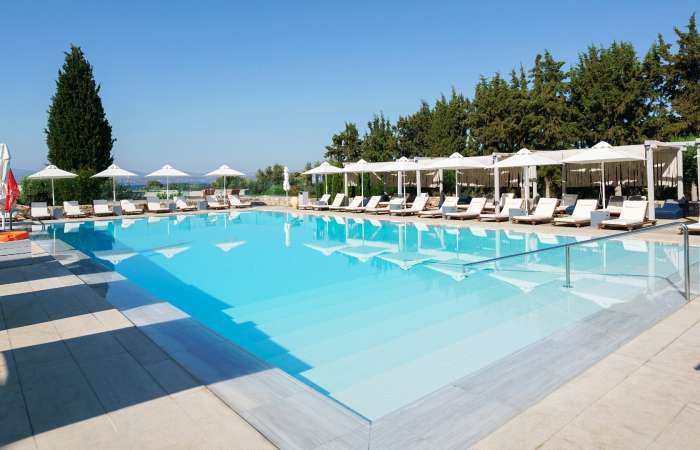 Swimmingpool med solsenge og parasoller