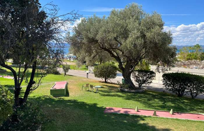 Skøn have med oliventræer og minigolf