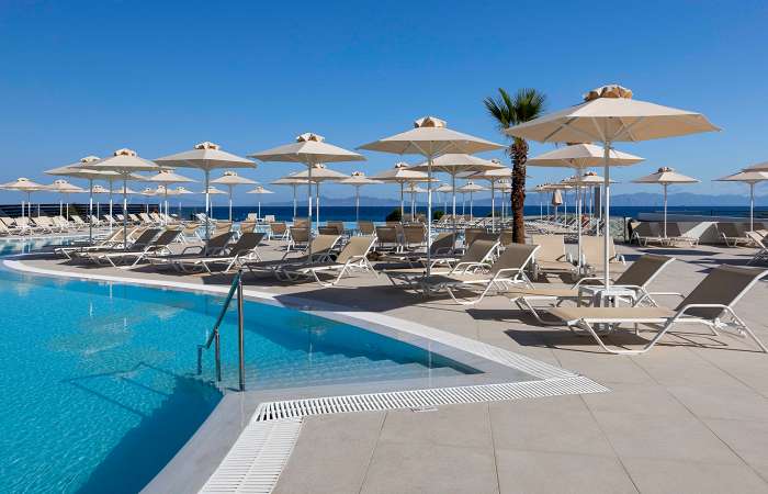 Poolområde med solstole og parasoller 