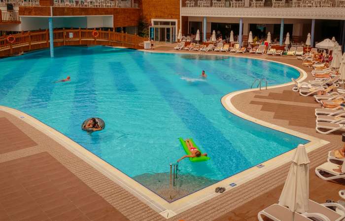 Poolområde med solstole og parasoller 