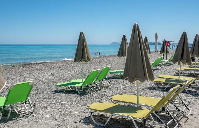 Strand med liggestole og parasoller