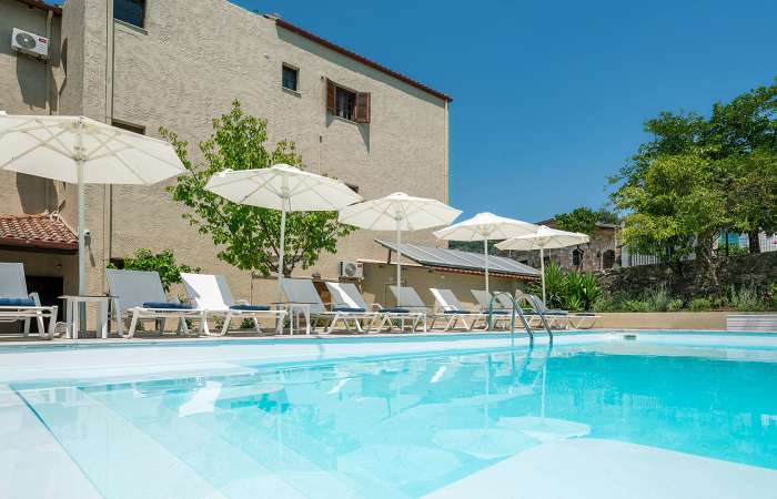 Poolområde med solstole og parasoller 